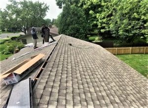 Roofers ready to install hip and ridge shingles on a new asphalt shingle roof